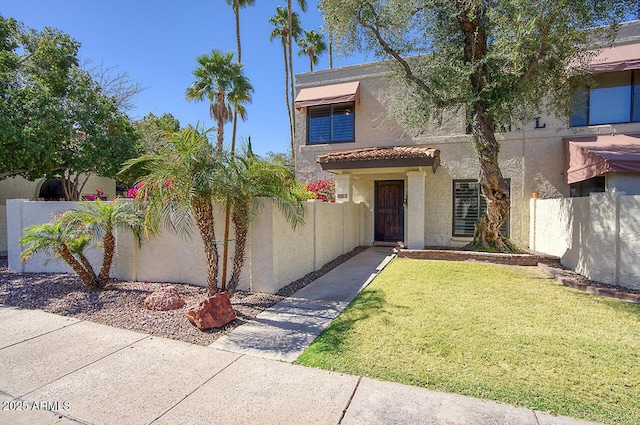 view of front of property featuring a fenced front yard, stucco siding, and a front yard