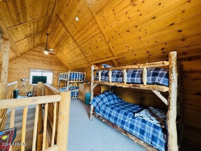 carpeted bedroom with lofted ceiling, wooden walls, and wooden ceiling