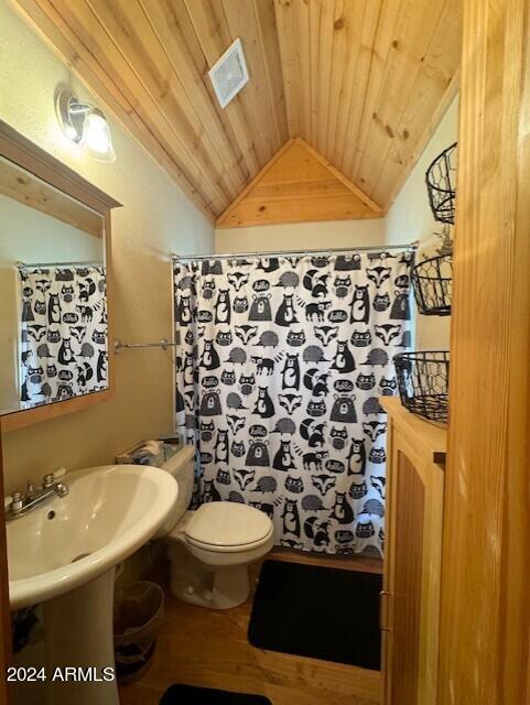 bathroom featuring lofted ceiling, walk in shower, wood ceiling, and toilet