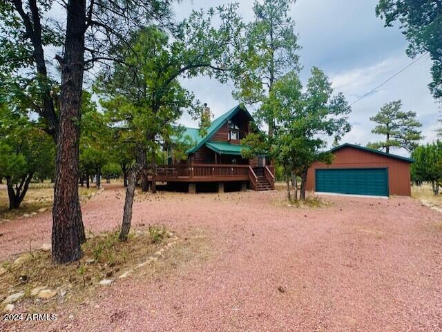 view of front of home featuring an outbuilding, a wooden deck, and a garage