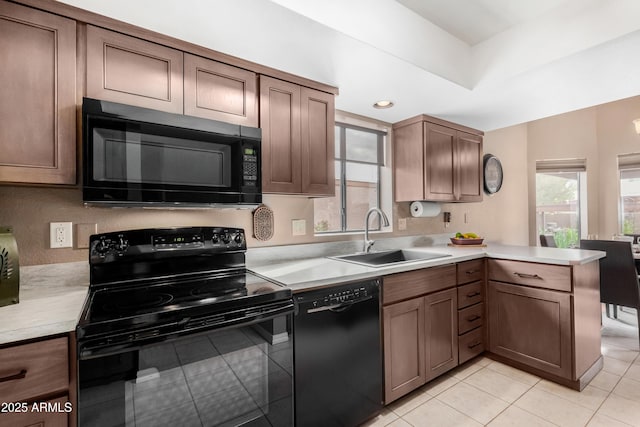 kitchen featuring kitchen peninsula, light tile patterned flooring, black appliances, and sink