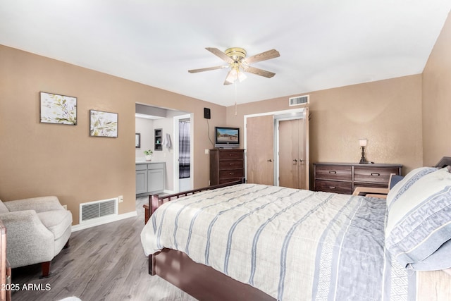 bedroom featuring ceiling fan, light wood-type flooring, and connected bathroom