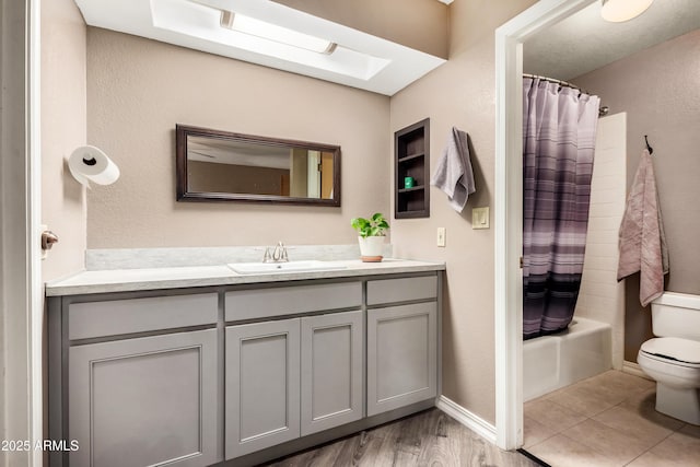 full bathroom featuring shower / bathtub combination with curtain, hardwood / wood-style flooring, vanity, and toilet