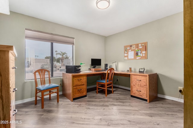 home office with light hardwood / wood-style flooring