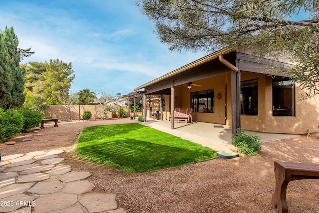 back of house featuring a patio area, ceiling fan, and a lawn