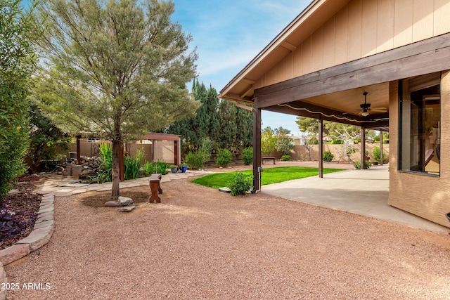 view of yard featuring ceiling fan and a patio