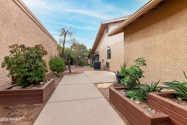 view of side of property featuring central AC and a patio area