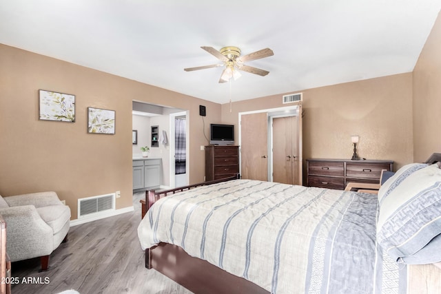 bedroom featuring connected bathroom, ceiling fan, and light hardwood / wood-style flooring