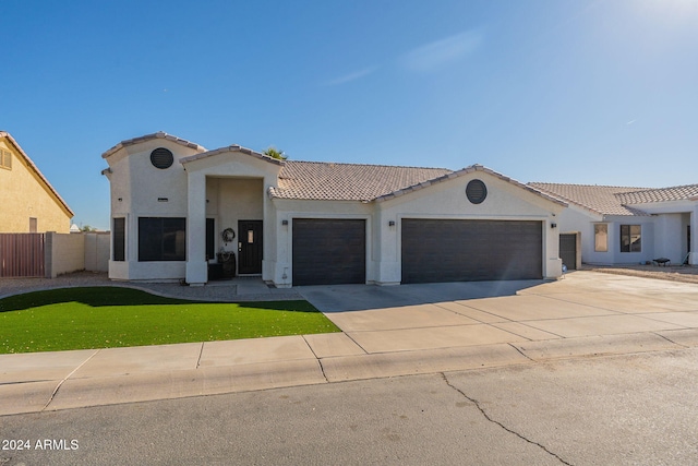 mediterranean / spanish house with a garage and a front yard