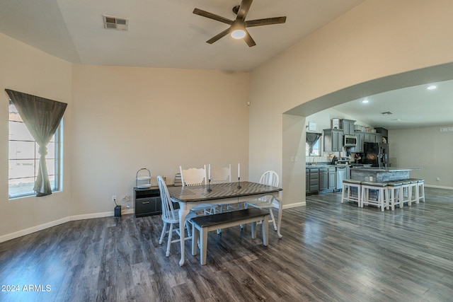 dining room with ceiling fan, dark hardwood / wood-style flooring, and high vaulted ceiling