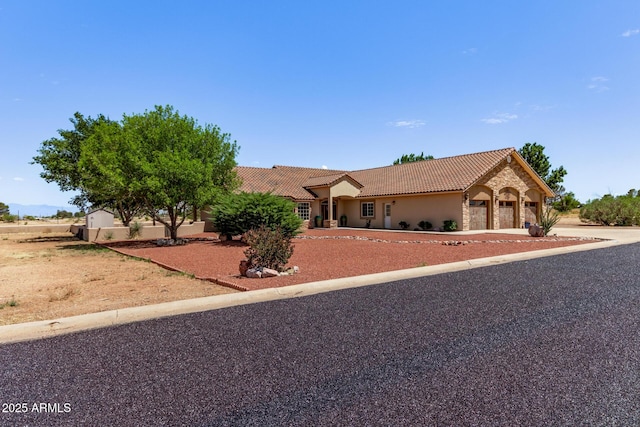 380 N Geneva Estates Rd, Pearce, AZ 85625 - view of front of house featuring a tile roof, an attached garage, stucco siding, and driveway