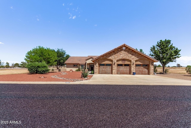 380 N Geneva Estates Rd, Pearce, AZ 85625 - view of front of house featuring stone siding, a garage, a tiled roof, concrete driveway, and stucco siding
