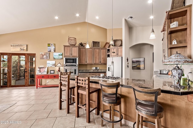 380 N Geneva Estates Rd, Pearce, AZ 85625 - kitchen with appliances with stainless steel finishes, open shelves, high vaulted ceiling, a peninsula, and a kitchen breakfast bar