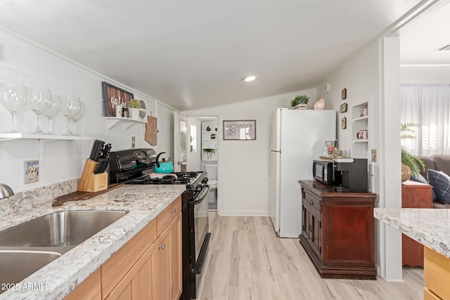 kitchen featuring lofted ceiling, black appliances, sink, light hardwood / wood-style flooring, and light stone counters