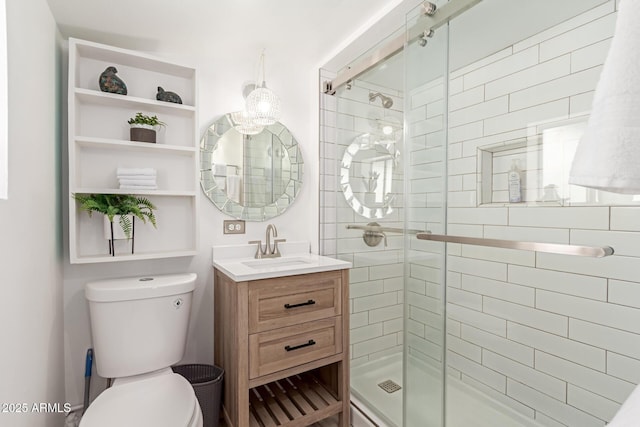 bathroom with toilet, vanity, and a shower with door