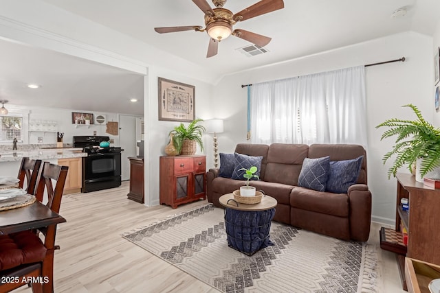 living room featuring ceiling fan and light hardwood / wood-style flooring