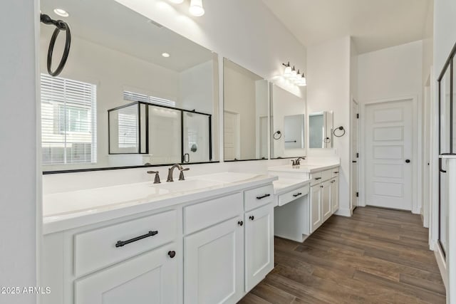 bathroom featuring hardwood / wood-style flooring, an enclosed shower, and vanity