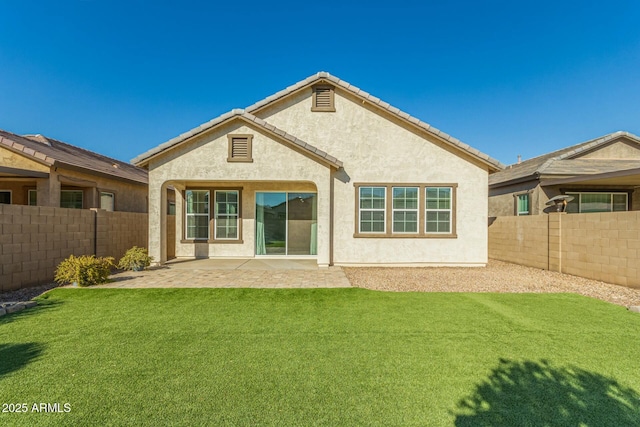 rear view of house featuring a lawn and a patio