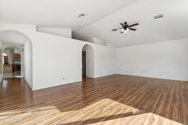 unfurnished living room featuring ceiling fan, vaulted ceiling, and dark wood-type flooring