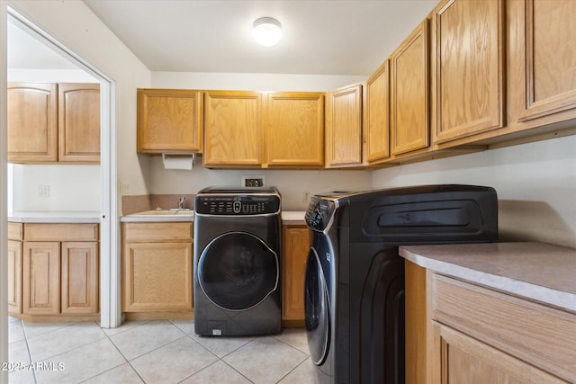 laundry room with cabinets, separate washer and dryer, light tile patterned floors, and sink