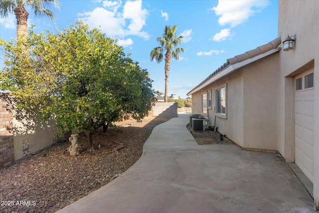 view of yard with central air condition unit and a patio area