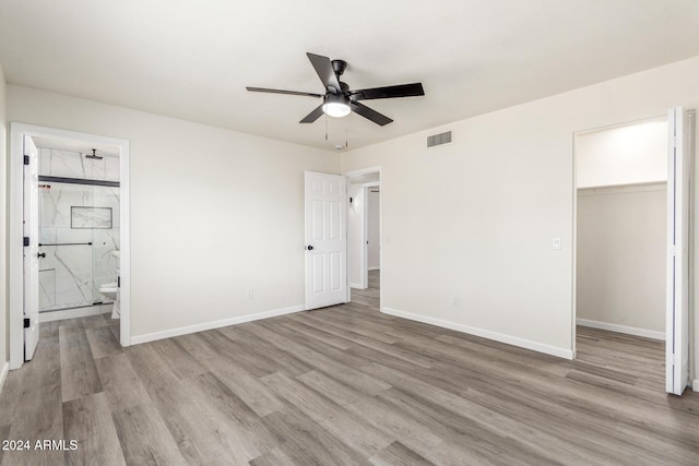 unfurnished bedroom with ceiling fan, light hardwood / wood-style floors, a spacious closet, and a closet