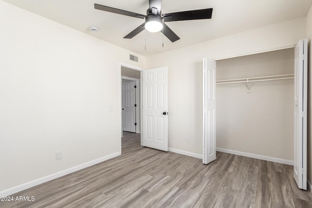 unfurnished bedroom featuring light wood-type flooring, a closet, and ceiling fan