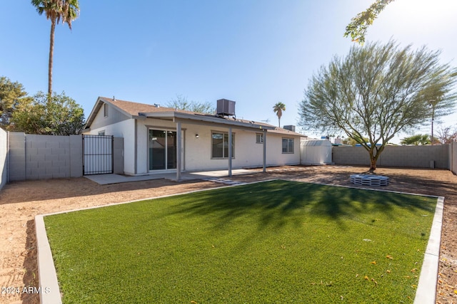 rear view of house featuring a yard and central AC