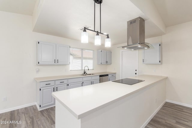 kitchen featuring ventilation hood, wood-type flooring, hanging light fixtures, stainless steel dishwasher, and kitchen peninsula