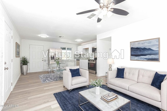 living room featuring ceiling fan and light hardwood / wood-style flooring