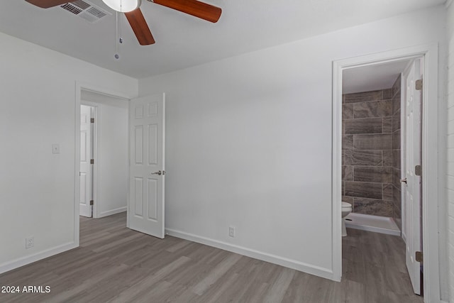 unfurnished bedroom with ensuite bath, ceiling fan, and light hardwood / wood-style flooring