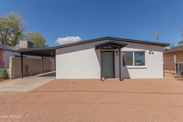 view of front of property featuring central AC and a carport