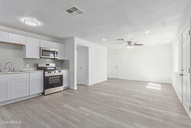 kitchen with sink, appliances with stainless steel finishes, ceiling fan, white cabinets, and light wood-type flooring