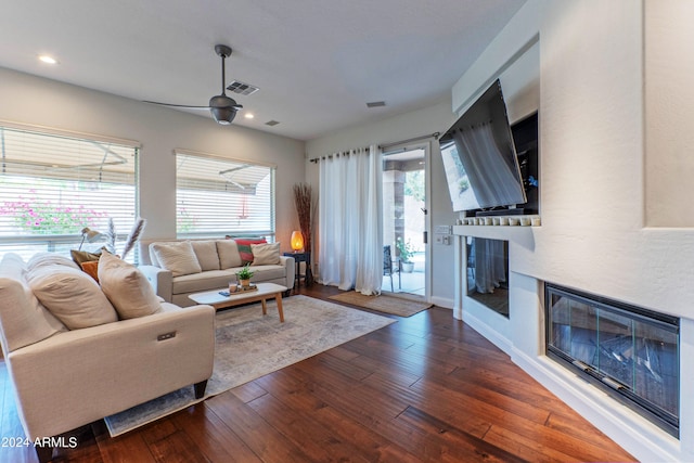 living room with ceiling fan and dark hardwood / wood-style floors