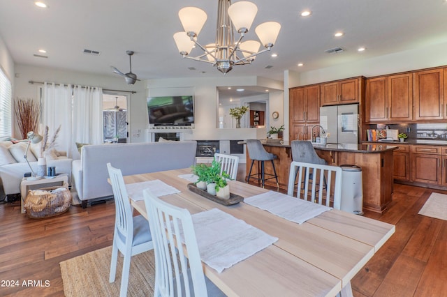 dining room featuring dark wood-type flooring and ceiling fan with notable chandelier