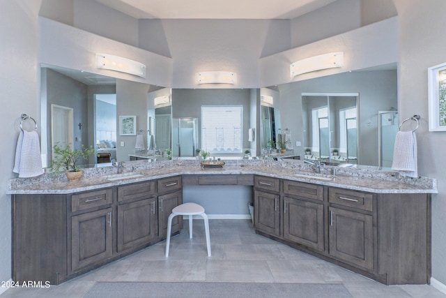 bathroom featuring vanity, walk in shower, a wealth of natural light, and vaulted ceiling