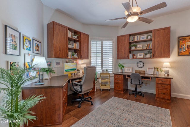 office featuring built in desk, dark wood-type flooring, and ceiling fan