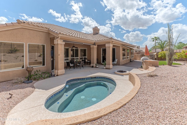 back of house with a patio area and an outdoor hot tub