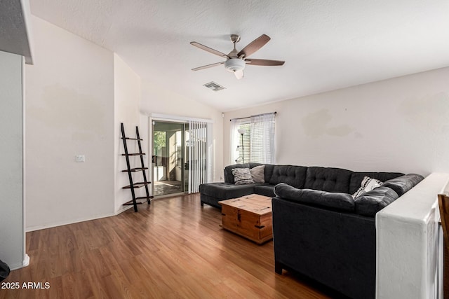 living room featuring wood-type flooring, a textured ceiling, ceiling fan, and vaulted ceiling