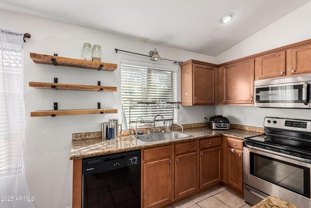 kitchen with appliances with stainless steel finishes, light tile patterned floors, dark stone counters, sink, and lofted ceiling