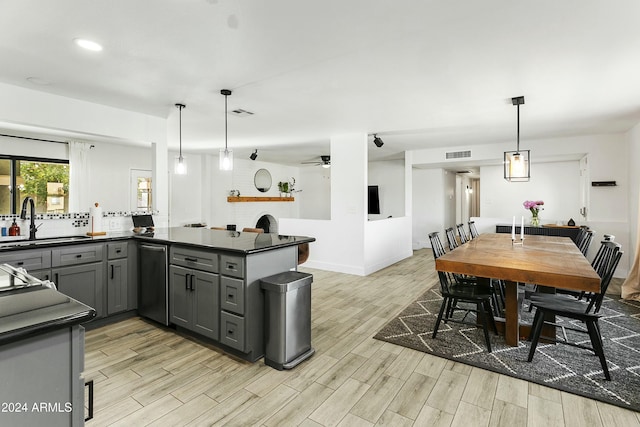 kitchen featuring gray cabinetry, decorative light fixtures, ceiling fan, and sink