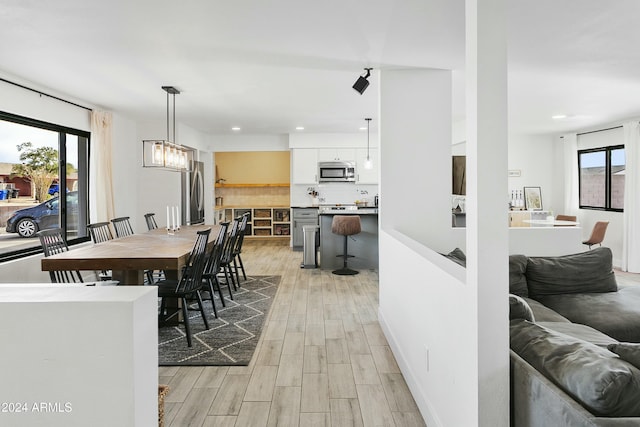 dining space with light hardwood / wood-style floors and a healthy amount of sunlight