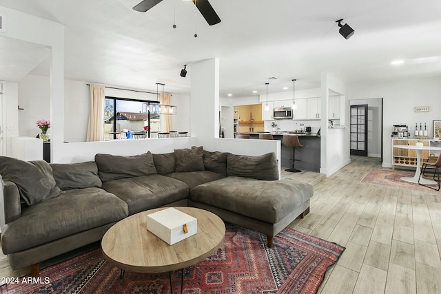 living room with ceiling fan and light hardwood / wood-style floors