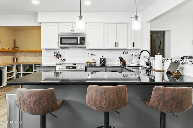 kitchen featuring white cabinets, pendant lighting, and sink