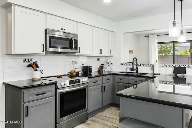 kitchen featuring gray cabinetry, pendant lighting, sink, appliances with stainless steel finishes, and white cabinetry