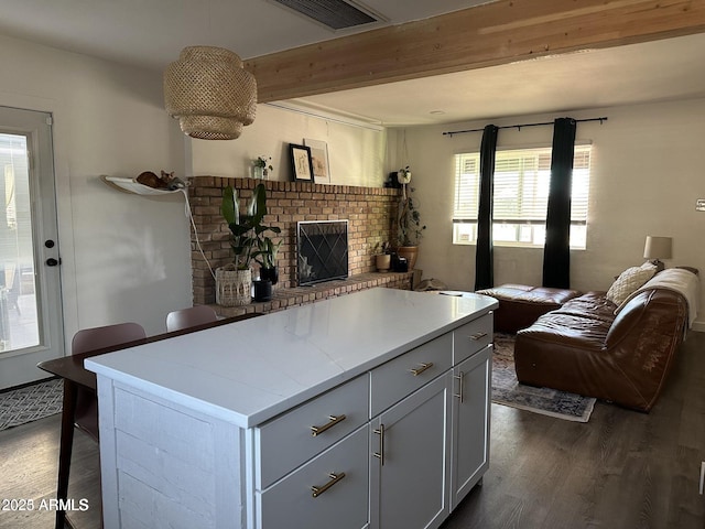 112 W Vogel Ave, Phoenix, AZ 85021 - kitchen featuring dark wood finished floors, open floor plan, beamed ceiling, a fireplace, and a center island
