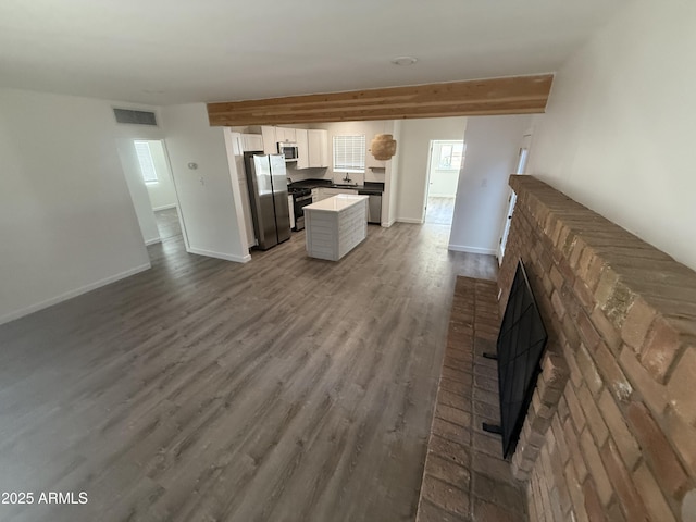 112 W Vogel Ave, Phoenix, AZ 85021 - kitchen featuring stainless steel appliances, open floor plan, white cabinetry, wood finished floors, and a fireplace