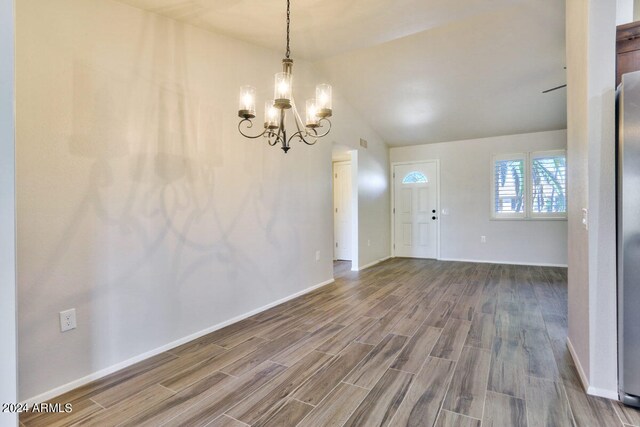 interior space with lofted ceiling, a chandelier, and hardwood / wood-style flooring