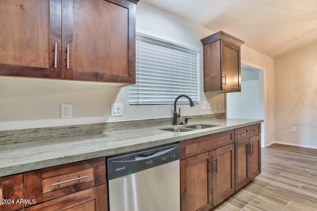 kitchen with light hardwood / wood-style flooring, light stone countertops, sink, and stainless steel dishwasher