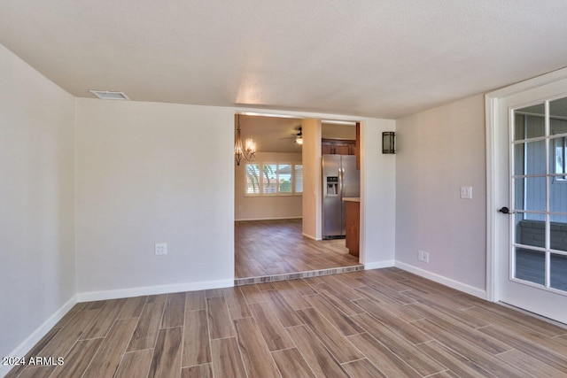 unfurnished room featuring a textured ceiling and hardwood / wood-style flooring